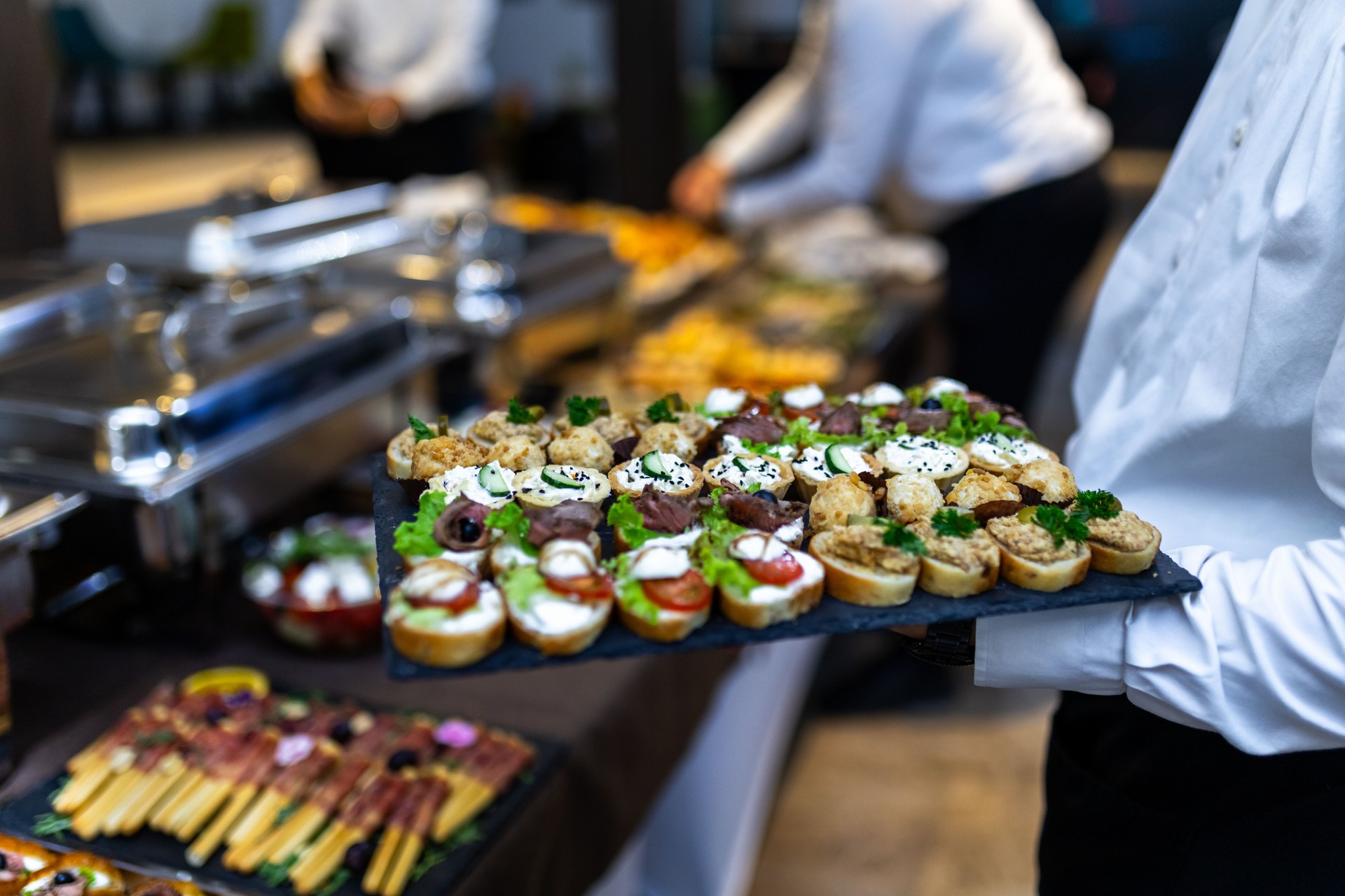 Elegant catering service presenting a variety of delicious appetizers at a formal event in an upscale venue